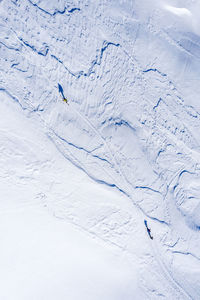 Aerial view of people walking on snow covered field