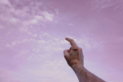 Low angle view of hand against sky