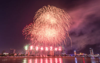 Firework display over river at night