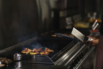 Person preparing food on barbecue grill