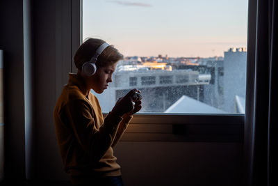 Side view of young man using phone