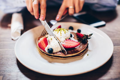 Close-up of hands eating pancakes