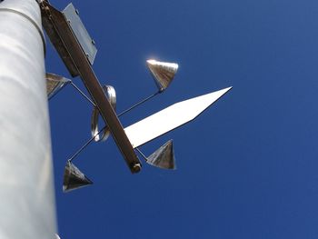 Low angle view of windmill against clear blue sky