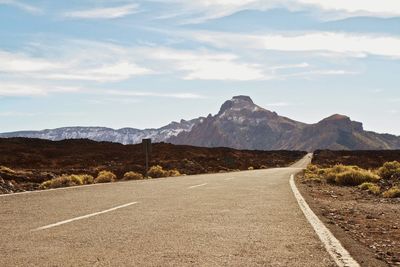 Empty road with mountains in background