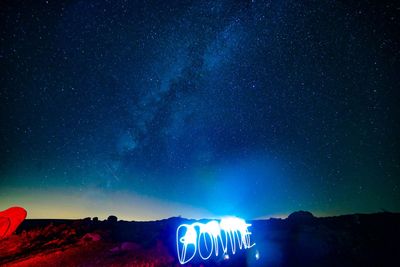 Light painting on field against sky at night