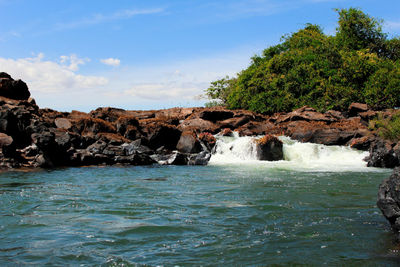 Scenic view of rocks in sea against sky