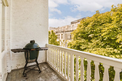 Rear view of woman sitting on railing against building