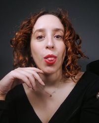 Portrait of young woman against gray background