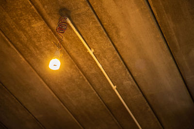 Low angle view of illuminated lamp on wall