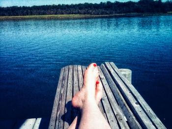 Low section of person relaxing on lake