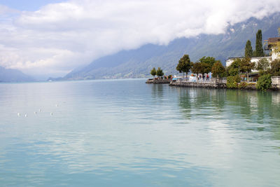 Scenic view of lake by buildings against sky