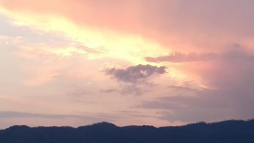 Low angle view of silhouette trees against dramatic sky