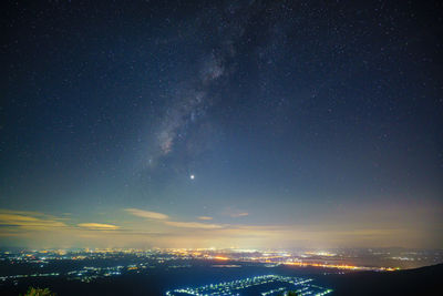 Aerial view of illuminated buildings against sky at night