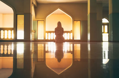 Rear view of woman standing in corridor