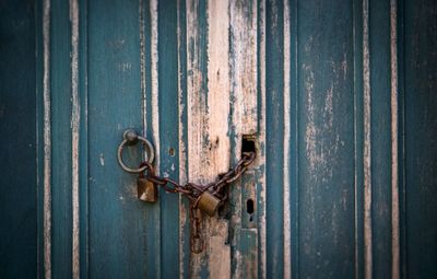 Close-up of rusty padlock on metal door