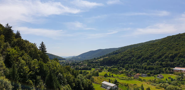 Scenic view of trees and mountains against sky