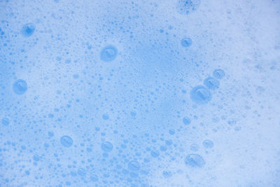 Close-up of water drops on blue surface