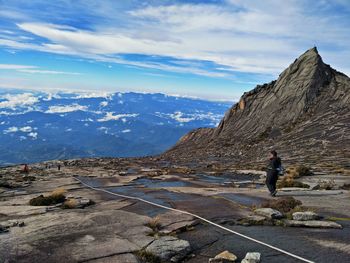 Man on rock against sky