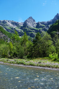 Scenic view of landscape and mountains against blue sky