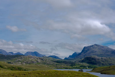 Scenic view of mountains against cloudy sky