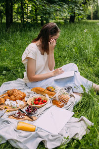 Portrait of young woman sitting on field