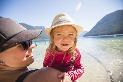 Mother holds her cute two year old daughter at the beach.