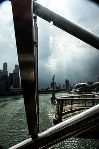 Bridge over river against cloudy sky