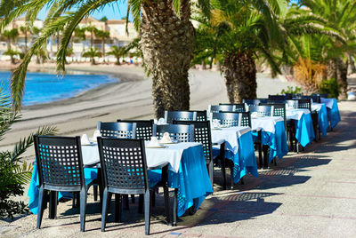 Tables and chairs arranged by footpath at la manga