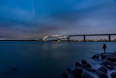 Bridge over sea against sky at dusk