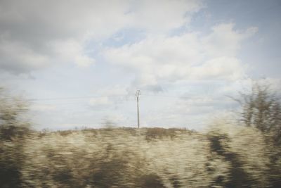 Scenic view of field against cloudy sky