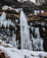 View of waterfall in forest during winter