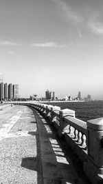 Bridge over river in city against sky