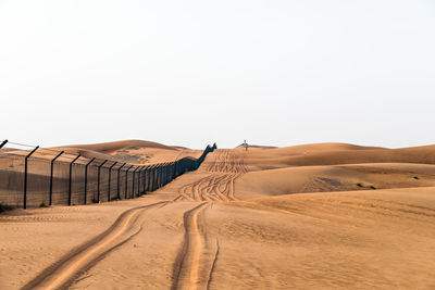 Sand dunes in desert against clear sky