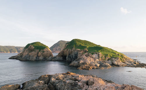 Rock formations in sea against clear sky