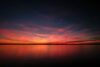 Scenic view of lake against romantic sky at sunset