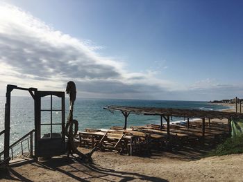 Chairs on beach against sky