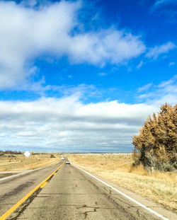 Empty road against cloudy sky