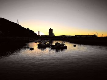 Boats in river at sunset