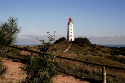 Lighthouse amidst trees and buildings against sky hiddensee 