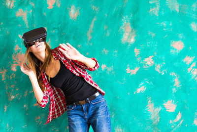 Woman standing outdoors wearing virtual reality headset