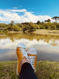 Low section of person in lake against sky