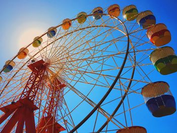 Low angle view of ferris wheel against blue sky