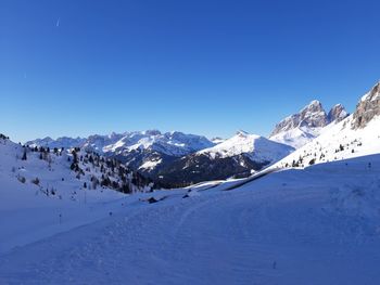 Scenic view of snowcapped mountains against clear blue sky