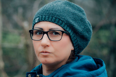 Portrait of mature woman wearing warm clothing while hiking in forest