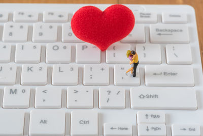 Close-up of heart shape and figurines on keyboard