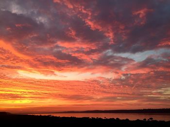 Scenic view of sea against cloudy sky at sunset