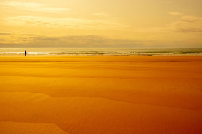 Scenic view of beach against sky during sunset