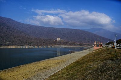 Scenic view of sea and mountains against sky