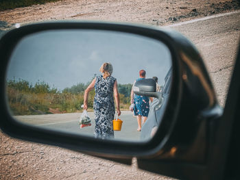 Reflection of people walking on road