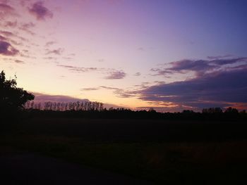 Scenic view of silhouette field against sky at sunset